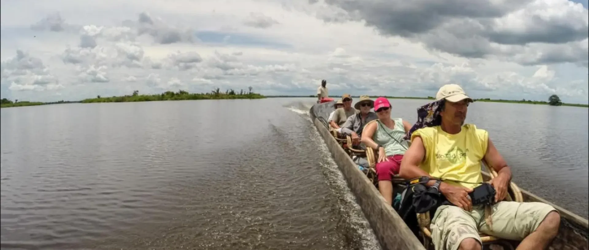 Travellers in a motorised canoe on the wide Sepik River.